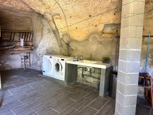 Buanderie rustique à la Maison Melrose à Vouvray avec lave-linge modernes et murs en pierre