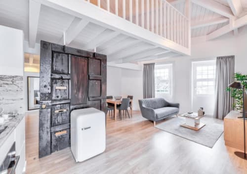 Suite loft moderno no Oporto Comfort Dom Hugo com vigas de teto brancas, sofá cinza, área de refeições e porta vintage escura.