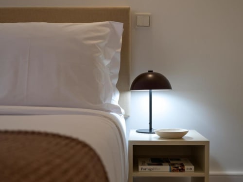 Quarto moderno com roupa de cama branca, cabeceira bege e luminária preta na Oporto Comfort Charming House no Porto