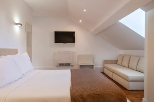 Quarto moderno na cobertura da Oporto Comfort Charming House com cama de casal, sofá, TV e vista para o jardim