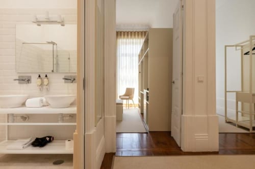 Banheiro e corredor da suíte moderna em Cedofeita, Porto, com dupla pia, closet e pisos em madeira