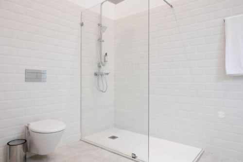 Banheiro moderno branco com chuveiro walk-in e sanitário na Oporto Comfort Charming House no Porto