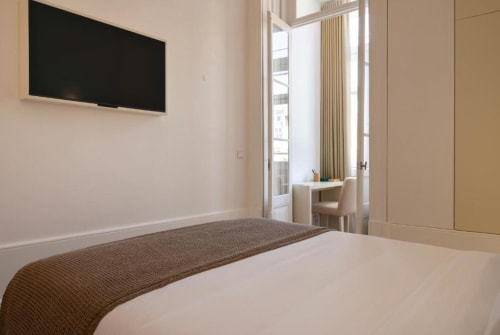 Quarto moderno na Oporto Comfort Charming House com vista para o jardim, TV de tela plana, escrivaninha e móveis contemporâneos