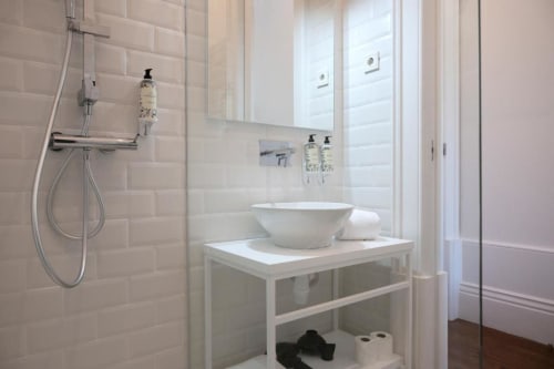 Banheiro moderno com lavatório e gabinete brancos na Oporto Comfort Charming House, Porto - área de banho com azulejos subway tile