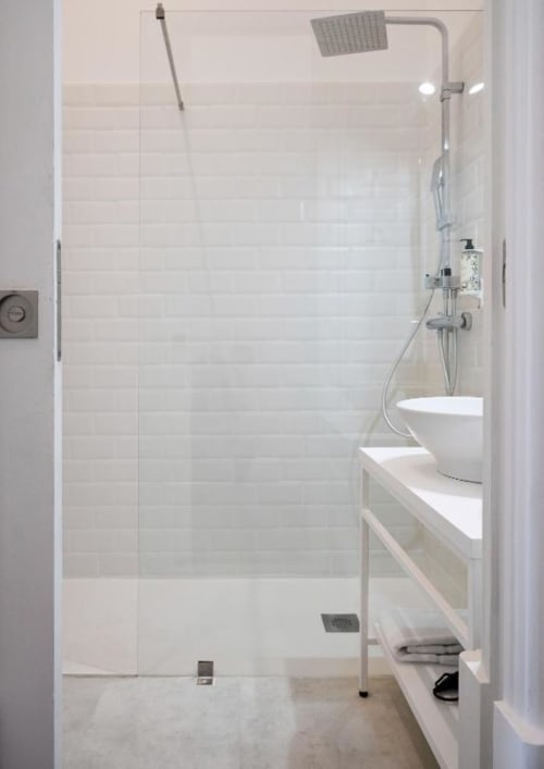 Banheiro moderno com chuveiro tipo walk-in, azulejos brancos, chuveiro tipo chuva e lavatório suspenso no Oporto Comfort Charming
