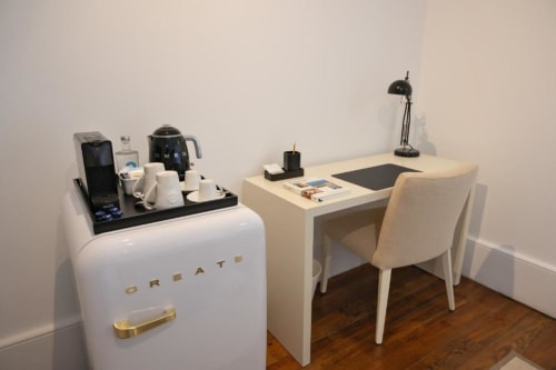 Quarto de hotel moderno com escrivaninha e cadeira, estação de café e luminária de mesa preta no Oporto Comfort Charming House no Porto