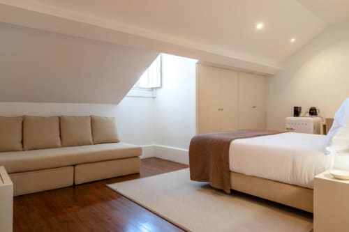 Quarto premium da Oporto Comfort Charming House com cama, sofá, claraboias e pisos em madeira