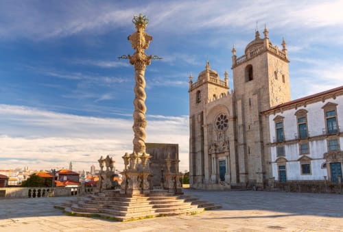 Catedral do Porto e cruz ornamentada em praça histórica, próximo ao Oporto Comfort Dom Hugo