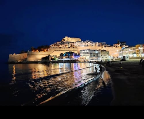 Peñíscola castle and beach at night with illuminated historic fortress overlooking Mediterranean coastline