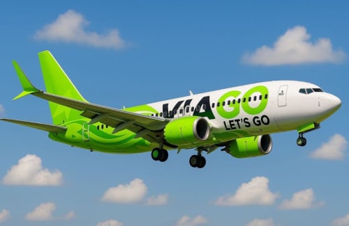 Bright green Kulula airline plane flying in blue sky with clouds