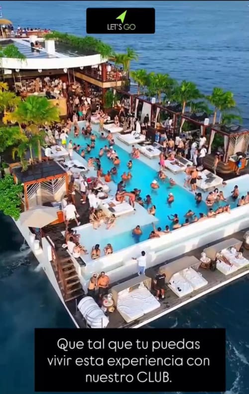Aerial view of RentalaYa! club pool with guests swimming and lounging by the seaside in Spain