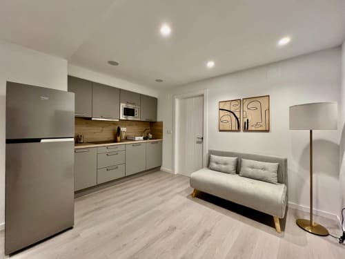 Estudio moderno en Architettura Apartamentos Úbeda con cocina americana, sofá cama y decoración minimalista