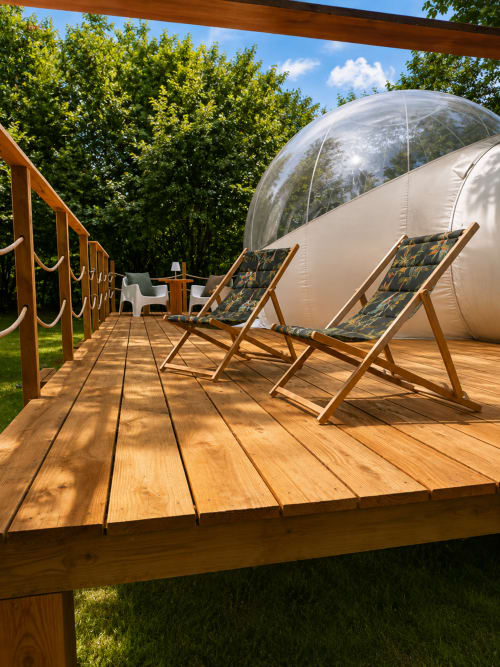 Dôme bulle transparent avec transats sur terrasse en bois à La Biche Au Bois, Moncléra