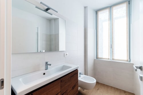 Bagno moderno a Lago Suites Como con doppio lavabo, specchio, wc e finestra con vista sulla città. Camera 101.