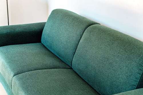 Poltrona rivestita in verde con cuscini nella suite 201 dell'hotel Lago Suites, Como