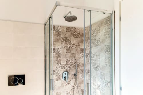 Moderna cabina doccia con rivestimento in piastrelle decorative marroni presso Lago Suites Como, Italia