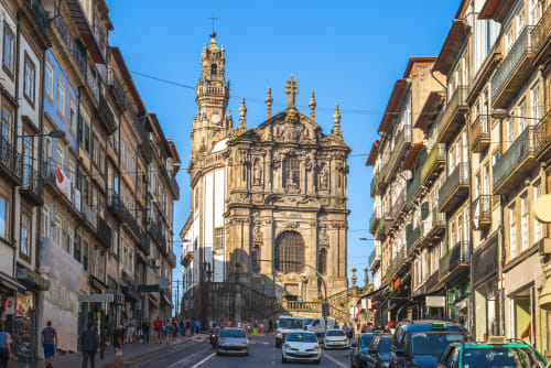 Rua histórica do Porto com igreja ornamentada e edifícios tradicionais no bairro de Cedofeita, Portugal