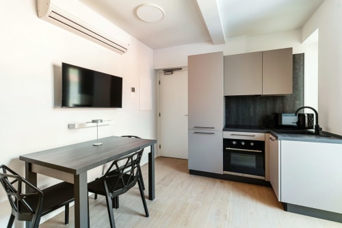 Cucina e zona dining moderni nella camera 302 di Lago Suites, Como, Italia con TV e vista città