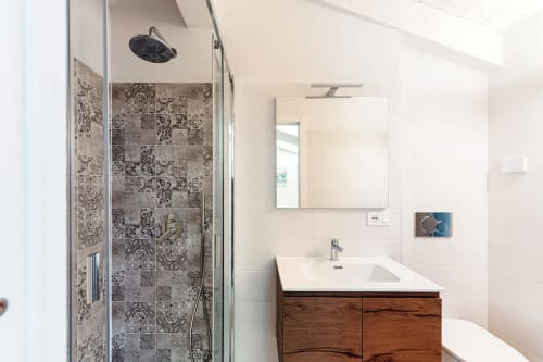 Bagno moderno di Lago Suites Como con doccia in piastrelle decorate, mobile vanity in legno e specchio