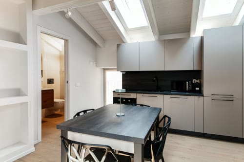 Cucina moderna con tavolo da pranzo al Lago Suites Como, con elettrodomestici in acciaio inox e lucernario