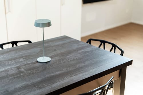 Tavolo da pranzo moderno presso Lago Suites Como con lampada sospesa blu e sedie nere contemporanee nella camera 401