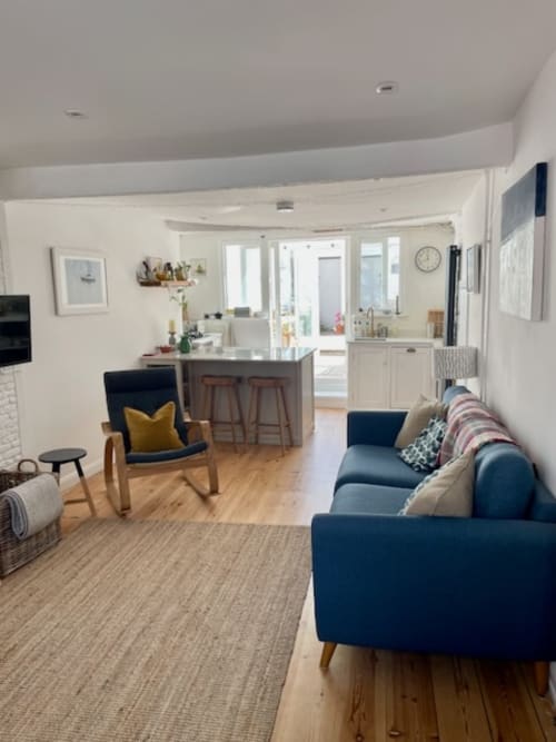 Open-plan living area at 2 Doves Holiday Property in Topsham with blue sofa, kitchen island, and dining space