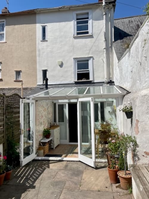 2 Doves Holiday Property villa in Topsham, Exeter featuring modern glass conservatory extension with outdoor dining area and