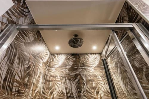 Moderna cabina doccia con carta da parati con motivi di foglie tropicali presso l'appartamento Lago Suites Como