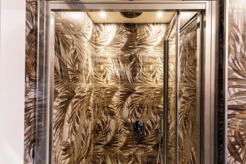 Ascensore moderno a Lago Suites Como con pareti decorate a motivi foglia dorata e struttura in acciaio inossidabile