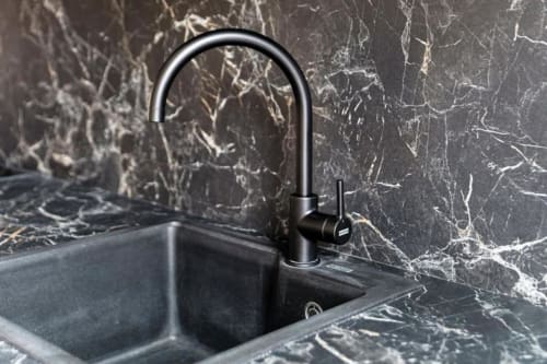 Moderno rubinetto nero e lavello con rivestimento in marmo nella suite di Lago Suites Como