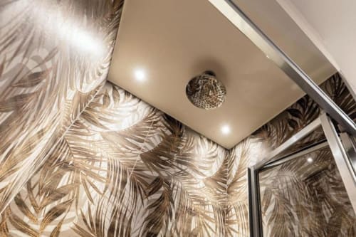 Soffitto moderno della suite al Lago Suites Como con illuminazione incassata, lampadario in cristallo e carta da parati con motivi botanici tropicali
