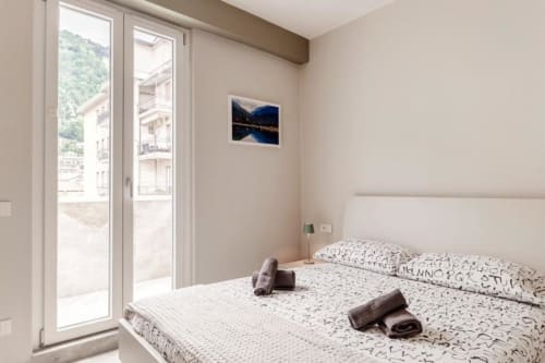 Camera luminosa presso Lago Suites Como con letto queen size, balcone con vista sul lago e servizi moderni