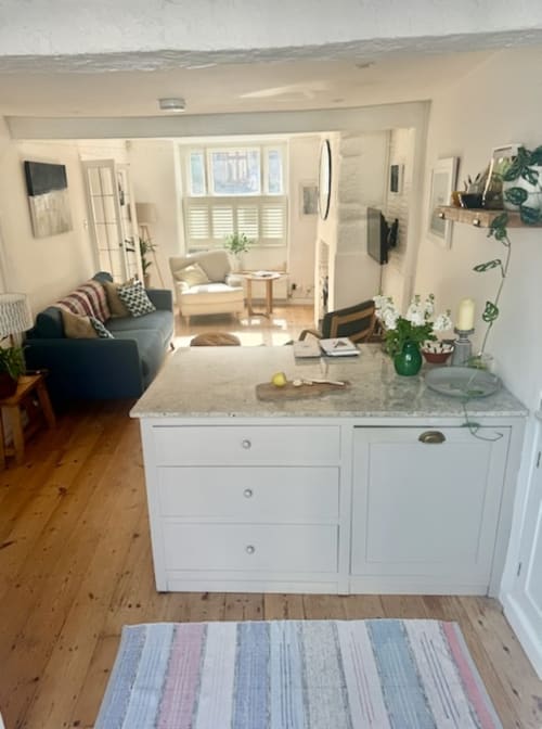 Open-plan kitchen and living area at 2 Doves Holiday Property in Exeter with white cabinetry, wooden floors, and