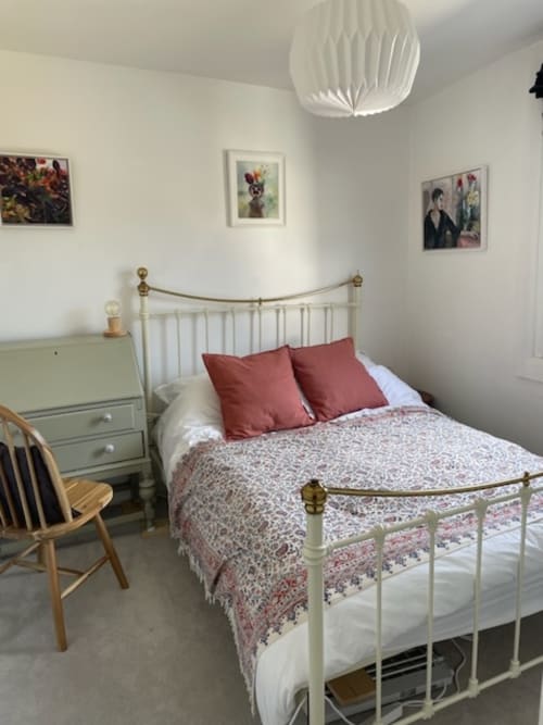 Cozy bedroom at 2 Doves Holiday Property in Topsham, Exeter with white metal bed frame and red pillows