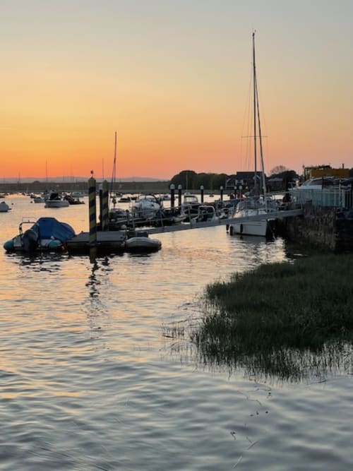 Sunset at Topsham marina with moored boats, sailboat, and waterfront near 2 Doves Holiday Property