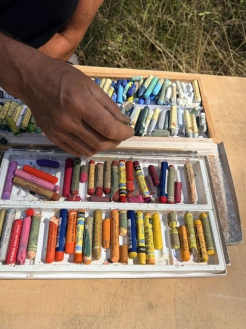 Hand opening art supplies and pastels at Domaine de l'Ocrerie BnB in Pourrain, France
