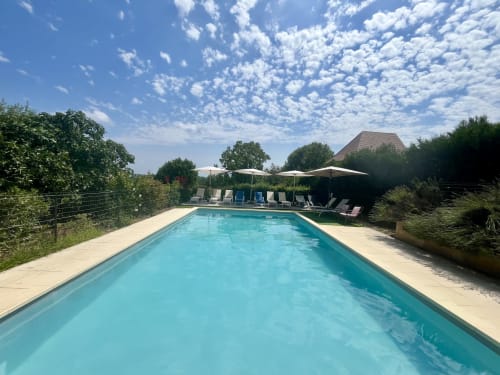 Rectangular swimming pool with turquoise water at Gîte La Vieille Ferme de La Doinie in Saint-Geniès, France, surrounded by