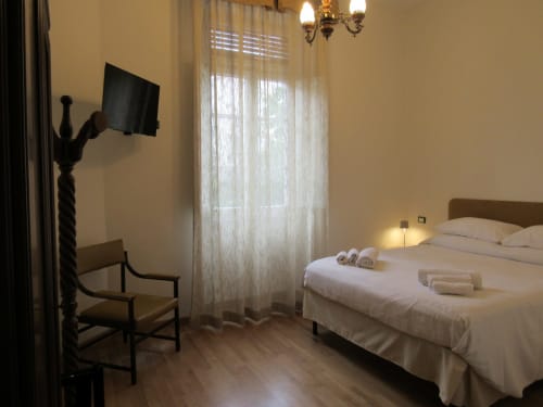 Camera Pane a Il 900 B&B di Avezzano: camera da letto con letto matrimoniale, TV, poltrona e finestre