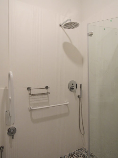 Moderno bagno accessibile con doccia a pioggia e maniglie di sicurezza nella Camera Pane dell'Il 900 B&B, Avezzano