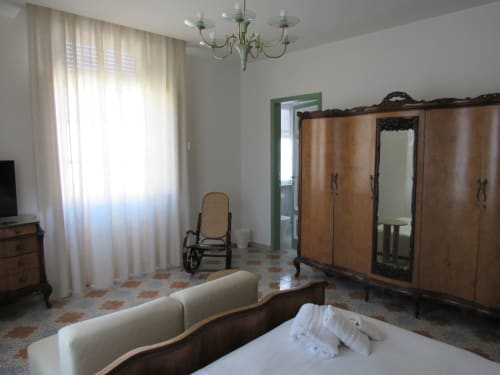 Camera Camelie presso Il 900 bed and breakfast ad Avezzano con arredamento classico, guardaroba e vista sulla città