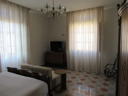 Camera Camelie al Il 900 B&B di Avezzano con TV, poltrona e finestre con vista sulla città