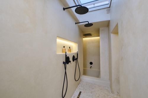 Modern shower room at EntreArcos Casa Eco-Boutique with black fixtures, rainfall showerhead, and ambient lighting in Vejer de