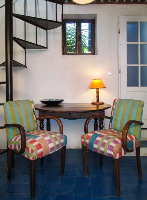 Zona soggiorno colorata al Clos B&B di Saint-Cyr sur Mer con sedie righe, tavolo rotondo e scala a spirale