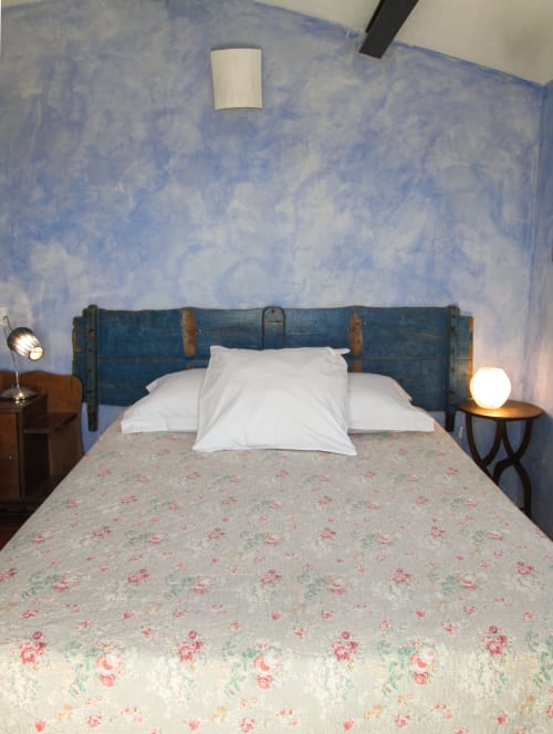 Camera accogliente al Clos B&B a Saint-Cyr sur Mer con testata blu, biancheria floreale e illuminazione soffusa