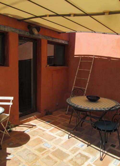 Terrazza del Clos Bb a Saint-Cyr sur Mer con tavolo a mosaico, sedie e tenda retrattile