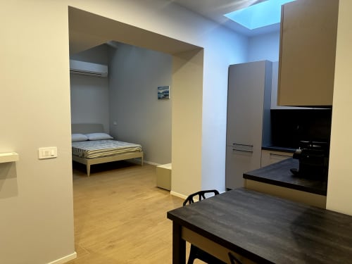 Lago Suites Como stanza 001: monolocale moderno con alcova letto, tavolo da pranzo, TV e servizi accessibili