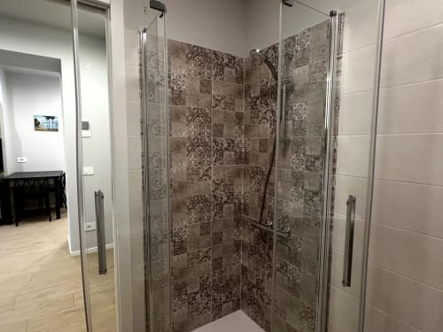 Moderna cabina doccia walk-in presso Lago Suites Como con piastrelle decorative e box doccia in vetro