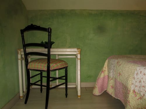 Camera da letto per ospiti al Clos Bb di Saint-Cyr sur Mer con pareti verdi, sedia nera e biancheria floreale