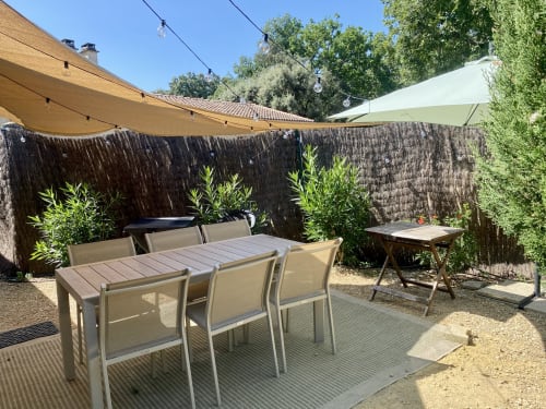 Private garden patio at Le Mas de la Soie with dining table, shade sails, and landscaping in Entrechaux