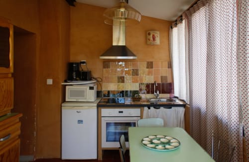 Cucina accogliente al Clos Bb a Saint-Cyr sur Mer con pareti arancioni, rivestimento in piastrelle e tavolo da pranzo